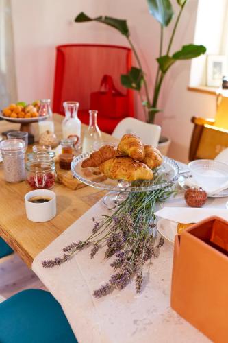 a table with a plate of pastries on it at Alma ART B&B in Dobrovo