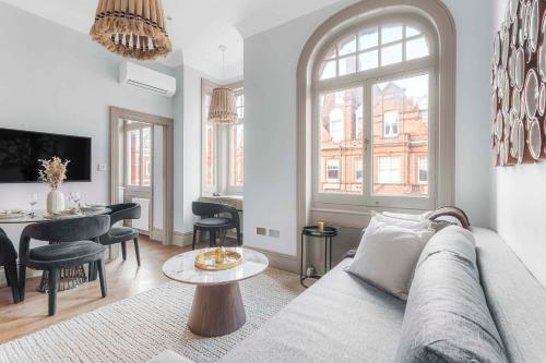 a living room with a couch and a table at Chic Chelsea Flat Near Harrods in London