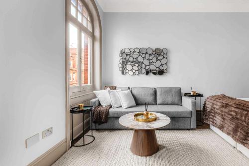 a living room with a couch and a table at Chic Chelsea Flat Near Harrods in London