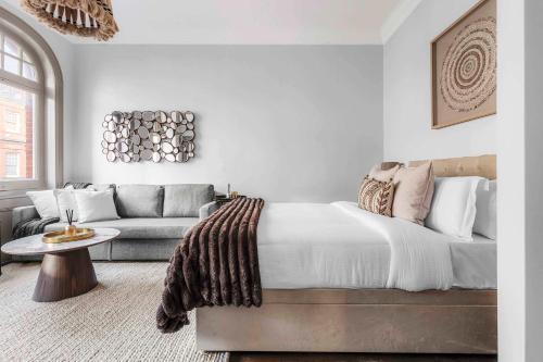 a bedroom with a large bed and a couch at Chic Chelsea Flat Near Harrods in London