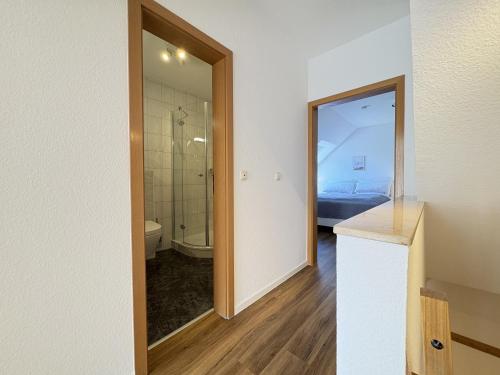 a bathroom with a glass door leading to a bedroom at Allee 1G - Meerzeit in Dahme