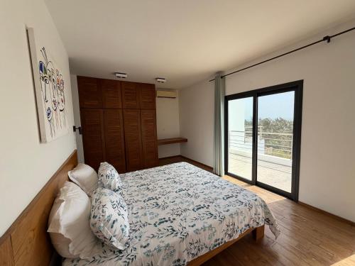 a bedroom with a bed and a large window at Maison des Alizés in Oussouye