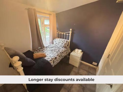 a small bedroom with a bed and a window at Shared Home - Self Check-In - Resident Cat in Hatfield
