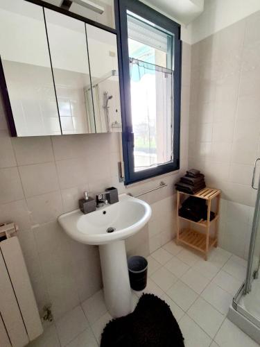 a white bathroom with a sink and a mirror at Sassonia beach in Fano