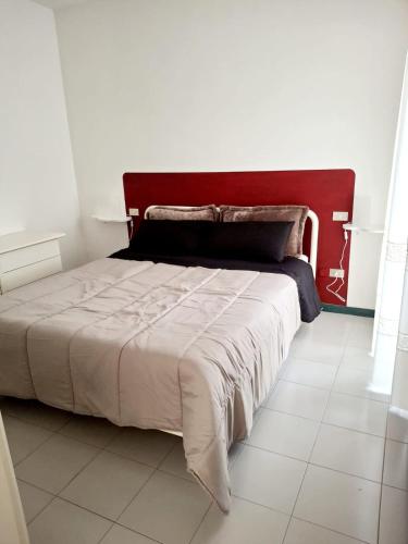 a bedroom with a large bed with a red headboard at Sassonia beach in Fano