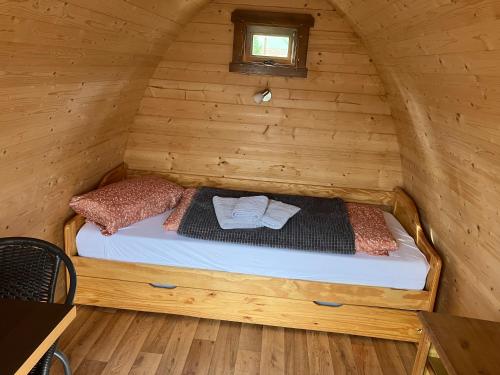 a bed in a wooden room in a cabin at Nr 5 Camping Pod mit Terrasse und Seeblick in Langenbernsdorf