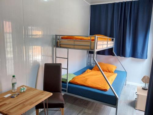 a small room with a bunk bed and a table at Tauber RadApart Kreativhof in Creglingen