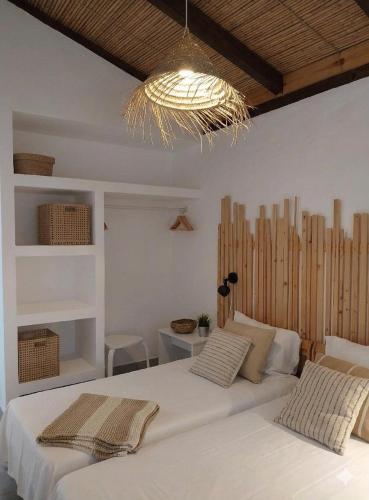 a bedroom with two white beds and a chandelier at Casa do Vale in São Bartolomeu
