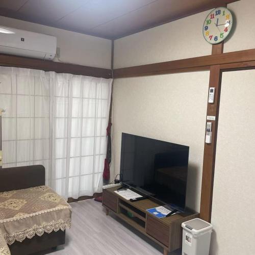 a bedroom with a tv and a clock on the wall at 独栋日式别墅巴士直达迪斯尼 in Tokyo