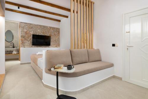 a living room with a couch and a tv at Onar -Quiet Luxury Suites with Private Jacuzzi-Ideal for Couples in Archangelos
