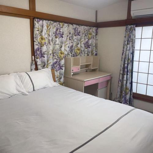 a bedroom with a bed and a desk and a window at 独栋日式别墅巴士直达迪斯尼 in Tokyo