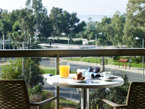 a table with a plate of food and a glass of orange juice at Golden Sun Hotel in Athens