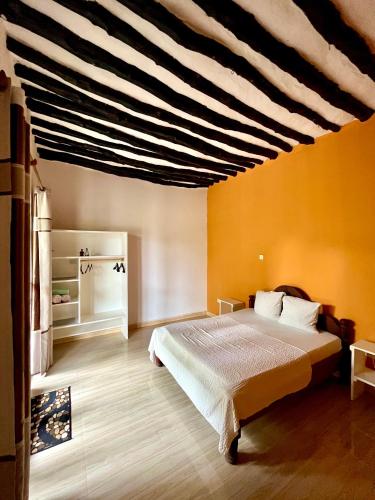 a bedroom with a bed and a striped ceiling at Apartments Maliki, Matemwe in Matemwe