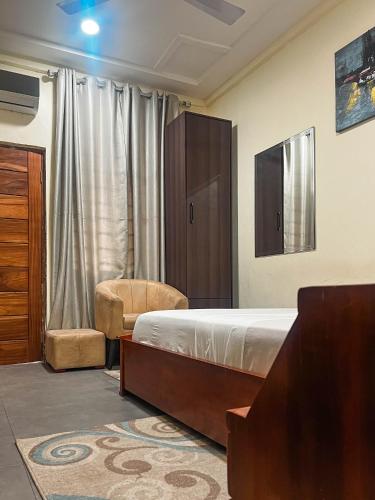 a bedroom with a bed and a chair and a cabinet at Christianborg in Trofwi