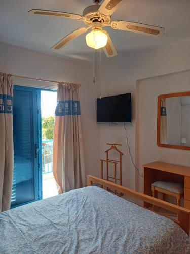 a bedroom with a bed and a ceiling fan at Latchi Holiday House in Prodhromi