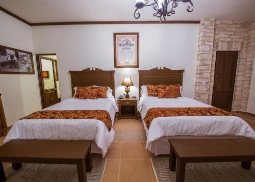 a hotel room with two beds and a fireplace at La Casona Minera in Mineral de Pozos