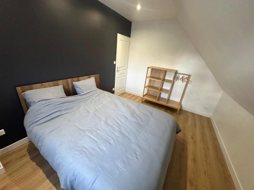 a bedroom with a large bed with white sheets at La Houblonnière Eperlecques Gite d'Ecou in Tilques