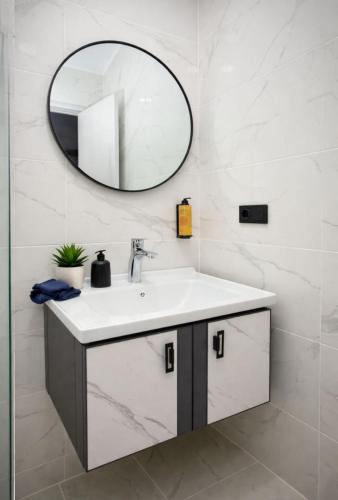 a bathroom with a sink and a mirror at DreamSide Aparthotel in Batumi
