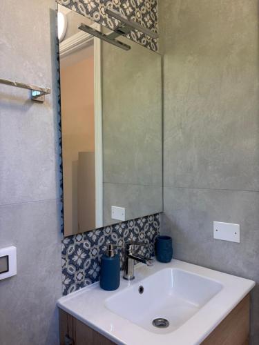 a bathroom with a sink and a large mirror at Soleada Club in Campofelice di Roccella