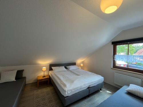 a bedroom with a bed and a window at Haus Stoertebeker Appartements - Hotel Garni, Seebad Lubmin in Lubmin