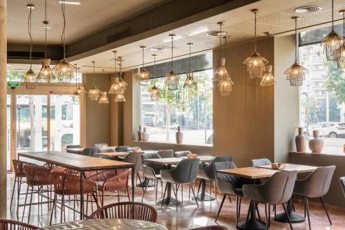 a restaurant with tables and chairs and pendant lights at Hotel SB Express Tarragona in Tarragona