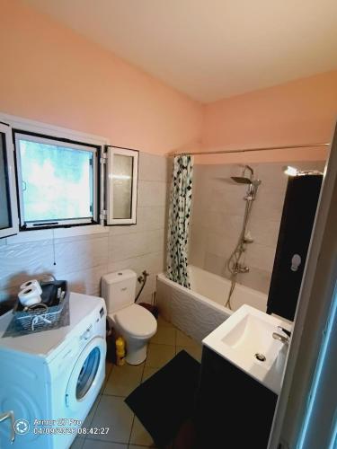 a bathroom with a washing machine and a sink at House Lantana 1432 in Pentátion