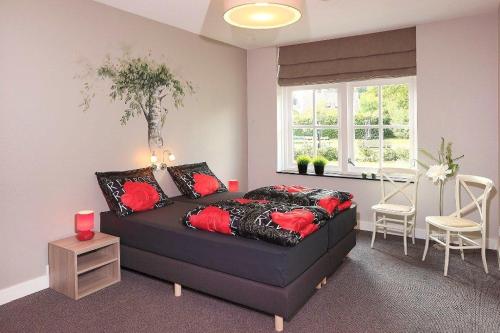 a bedroom with a black bed with red pillows at De Sterre in Losser