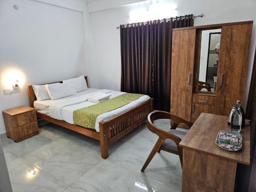 a bedroom with a bed and a table and a chair at Nest Mountain Munnar in Munnar