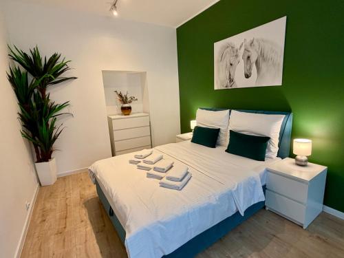 a green bedroom with a bed with towels on it at Apartment Targowa L9 in Lublin