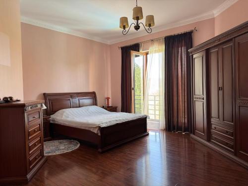 a bedroom with a bed and a dresser and a window at Aisi Villa in Misakʼtsʼieli