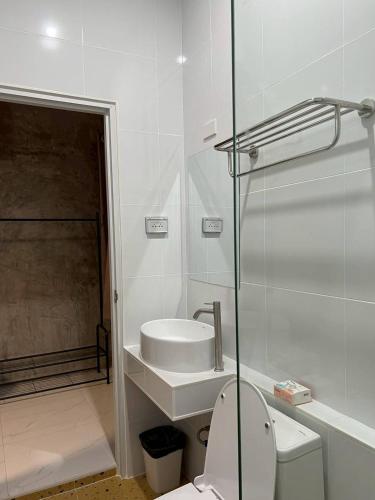 a white bathroom with a toilet and a sink at K-Am คราม อมตะ รีสอร์ต in Ban Yan Su