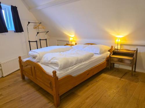 a bedroom with a bed with white sheets and a piano at Vakantiewoning Veere VE01 in Veere