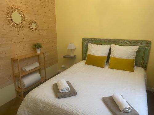 a bedroom with a bed with towels on it at couleurs d'ici in Fleurance