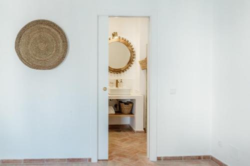 a bathroom with a mirror and a sink at Casa do Céu - Casas do Levante in Olhão
