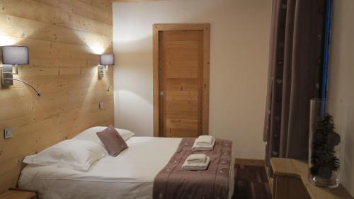 a bedroom with a bed and a wooden wall at Le Dahu in Chamonix-Mont-Blanc
