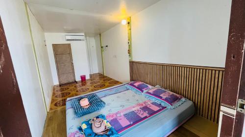 a small room with a bed in the corner of a room at Happy Fuji Homestay in Ko Phrao Nai