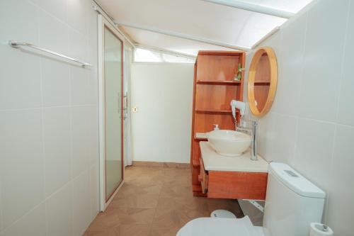 a bathroom with a sink and a toilet and a mirror at Svargan Lakeside Glamping in Tabanan