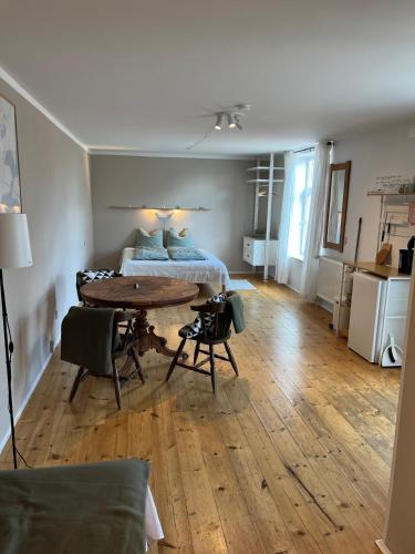 a living room with a table and a bed at Rinkenæshus Das Grosses Zimmer in Gråsten