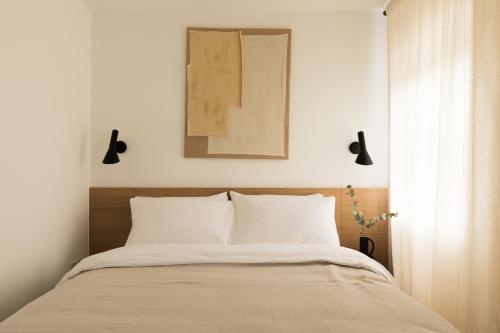 a bedroom with a bed and a picture on the wall at The Japandi Escape - 2BR Duplex in Central Oxford in Oxford