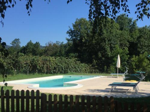 a swimming pool with a table and a bench next to a fence at Agriturismo Turina in Bricherasio