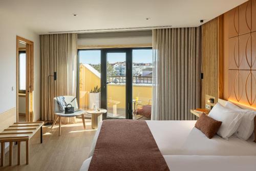ein Hotelzimmer mit Bett und Balkon in der Unterkunft Hotel do Alboi in Aveiro