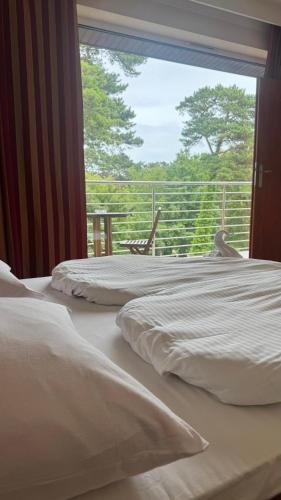 two beds in a room with a view of a balcony at Floryda in Jurata