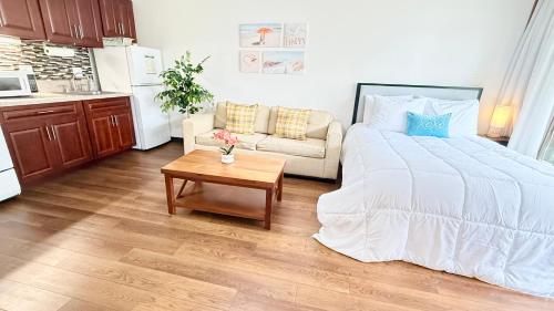 a bedroom with a white bed and a coffee table at Free parking Comfy central Waikiki in Honolulu