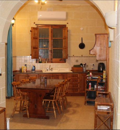 a kitchen with a large wooden table and chairs at Shamrock House in Qala