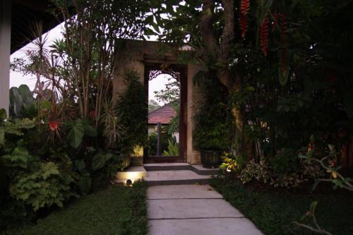 a walkway leading to a house with a doorway at The Samara Villas & Restaurant in Ubud