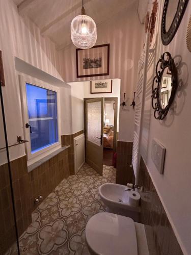 ein Badezimmer mit Toilette, Waschbecken und Fenster in der Unterkunft Tasso9 in Boccheggiano