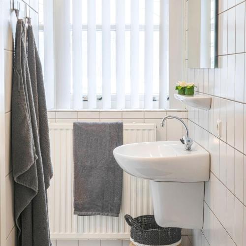 a white bathroom with a sink and a mirror at De Regenboog in Losser