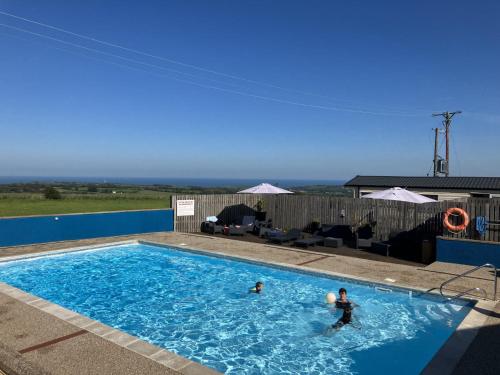 two people are swimming in a swimming pool at Bardsey View Holiday Park Nr New Quay in Llanarth