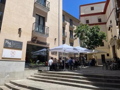 a group of people sitting under umbrellas outside a building at Edificio Histórico en el Centro de Granada cerca de la Catedral y principales puntos de interés in Granada