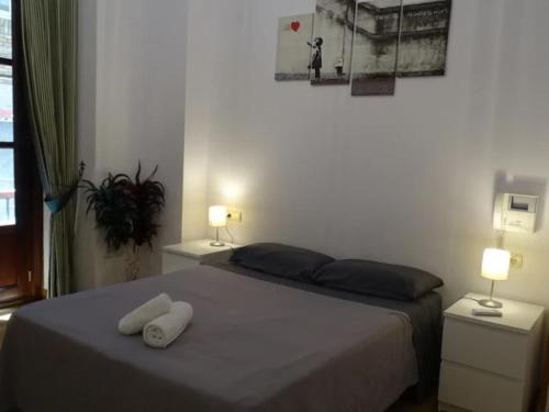a bedroom with a bed with two towels on it at Edificio Histórico en el Centro de Granada cerca de la Catedral y principales puntos de interés in Granada